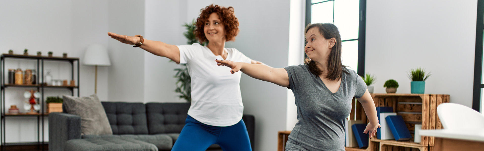 Mature mother and down syndrome daughter doing exercise at home