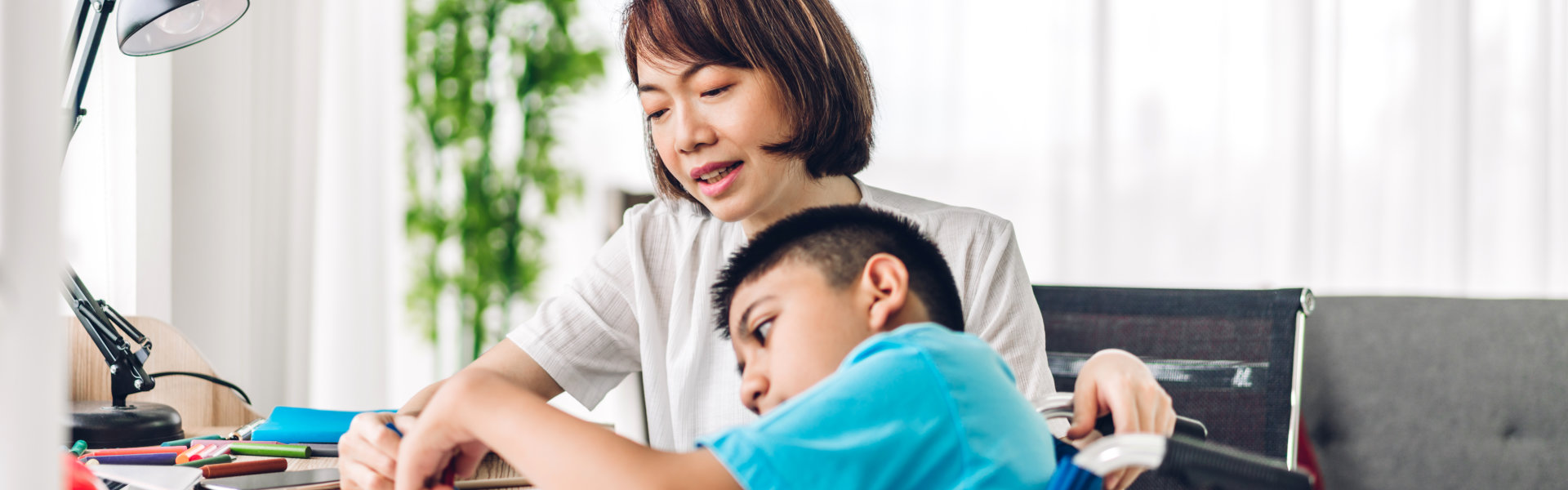 Portrait of enjoy happy love family asian mother playing and carer helping look at disabled son child sitting in wheelchair