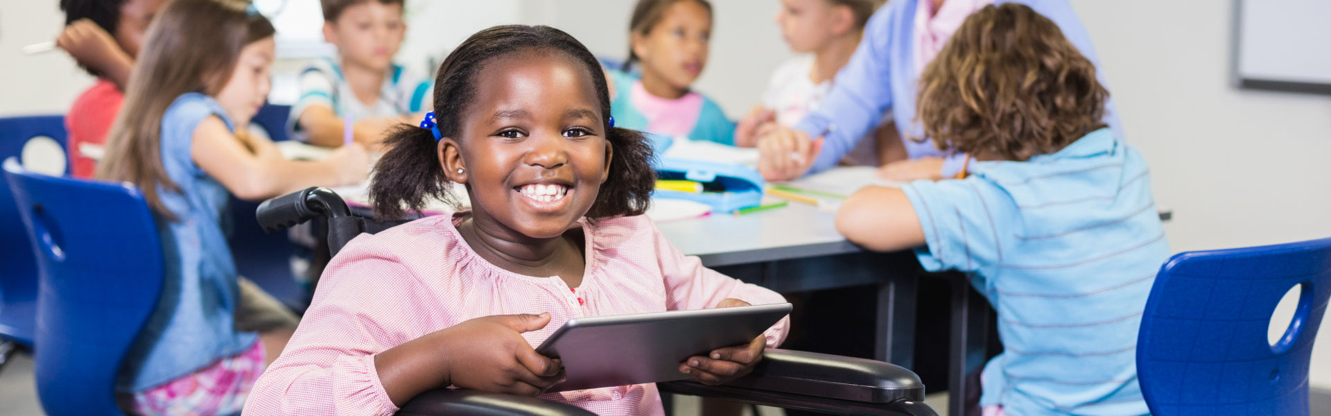 Disabled schoolgirl using digital tablet in classroom at school